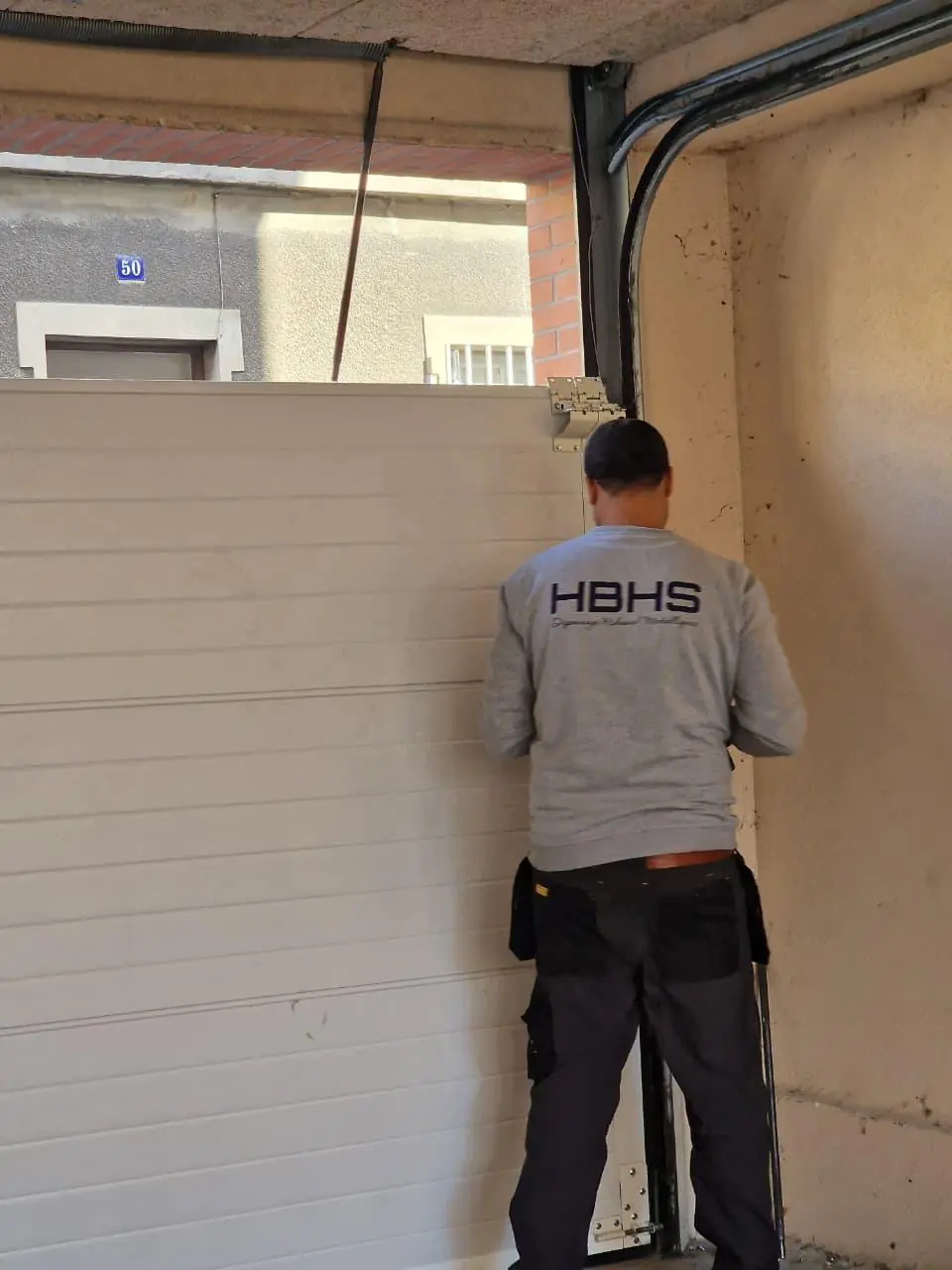 pose porte de garage sectionnelle hbhs